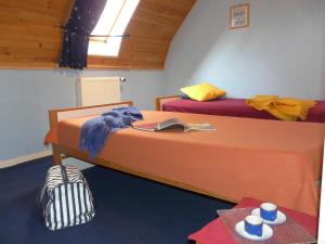 um quarto com duas camas e uma mesa com um livro em Gite Les Sources em Marcillac-la-Croisille