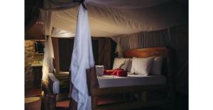 a bedroom with a bed with a canopy at Lake Natron Tented Camp in Mtowabaga