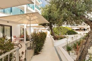 ein Balkon mit Sonnenschirm, Tisch und Stühlen in der Unterkunft Hotel Best Sol D´Or in Salou
