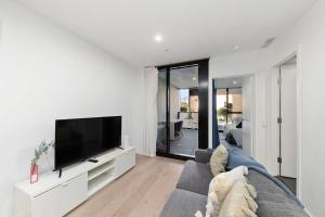 a living room with a couch and a flat screen tv at 2BR-1BR-1Car- CBD Pool Central in Canberra