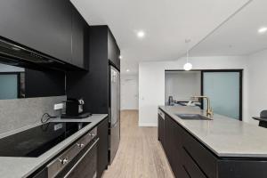 a kitchen with black cabinets and a counter top at 2BR-1BR-1Car- CBD Pool Central in Canberra