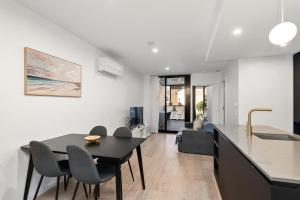 a kitchen and living room with a table and chairs at 2BR-1BR-1Car- CBD Pool Central in Canberra +10 photos