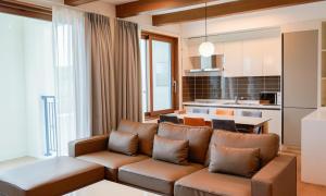 a living room with a couch and a kitchen at Sagewood Yeosu Gyeongdo Resort in Kyŏngho-dong
