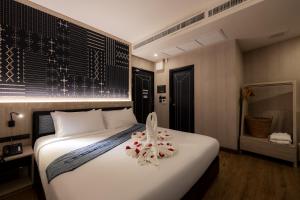 a bedroom with a large white bed with flowers on it at Salee Boutique Hotel in Chiang Mai
