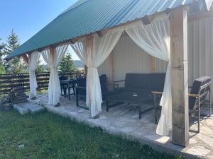 a gazebo with a table and chairs under it at Mountain Peace Cottage in Žabljak