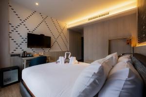 a hotel room with a bed and a flat screen tv at Salee Boutique Hotel in Chiang Mai
