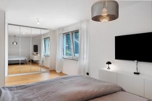 a bedroom with a bed and a flat screen tv at Modern House, Pool, Garden in Burgdorf +32 photos