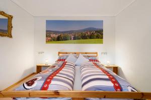 a bedroom with two beds with a picture on the wall at Gemütliches 3-Sterne Ferienhaus in Zwiesel