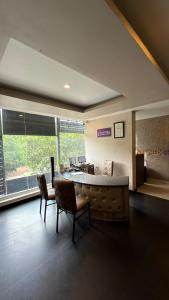 a living room with a couch and a table and chairs at Astra Hotels and Suites HSR Sector 1 in Bangalore