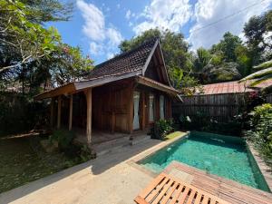 a house with a swimming pool in front of it at Sarini Joglo Villa by Manara in Blahbatu