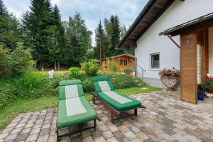 two green chairs and a bench on a patio at Gemütliches 3-Sterne Ferienhaus in Zwiesel +25 photos