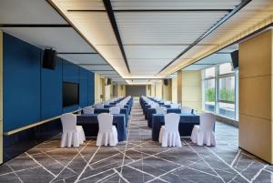 a conference room with blue tables and white chairs at Four Points by Sheraton Rizhao Central Activities Zone in Rizhao