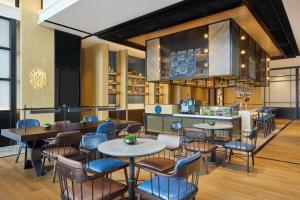 a restaurant with tables and chairs and a counter at Four Points by Sheraton Rizhao Central Activities Zone in Rizhao