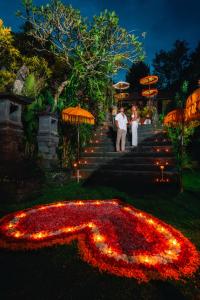 a bride and groom standing in front of a flower arrangement at Hanging Gardens of Bali in Payangan +114 photos