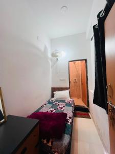 a small room with a bed and a cabinet at Hotel Viny villa in Udaipur