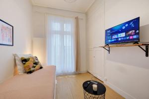 a living room with a couch and a flat screen tv at Viktor 1 - Studio Hyper Centre - Place Jean Jaurès in Tours