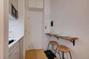 a small kitchen with two stools and a counter at Viktor 1 - Studio Hyper Centre - Place Jean Jaurès in Tours +15 photos