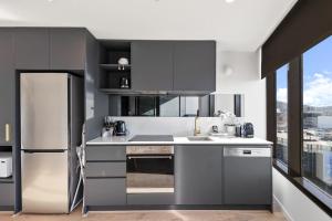a kitchen with a refrigerator and a sink at 1BR-1BR-1Car-Sleeps 4-Pool-CBD in Canberra