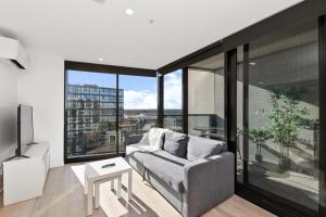 a living room with a couch and a large window at 1BR-1BR-1Car-Sleeps 4-Pool-CBD in Canberra