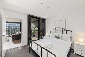 a bedroom with a large white bed and a balcony at 1BR-1BR-1Car-Sleeps 4-Pool-CBD in Canberra +11 photos