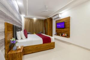 a hotel room with a bed and a tv at Soothing Stayz - Near Medanta The Medicity in Gurgaon +24 photos