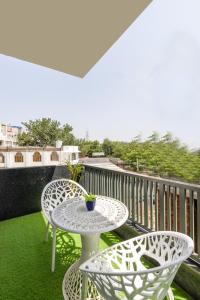 a table and two chairs on a balcony at Soothing Stayz - Near Medanta The Medicity in Gurgaon
