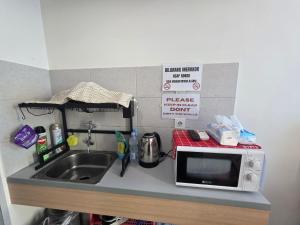 a kitchen counter with a sink and a microwave at OSAKA RIVERVIEW in Tangerang