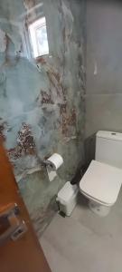 a bathroom with a toilet and a wall covered in paint at Georgia's house in Maronia +8 photos