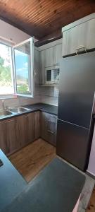 a kitchen with a refrigerator and a sink and a window at Georgia's house in Maronia