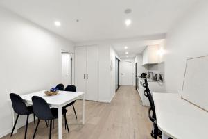 a kitchen and dining room with a white table and chairs at 2B-1BR-1Car-Courtyard-CBD-Shops in Canberra