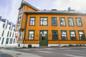 an orange building with a green door on a street at Moderne leilighet i Gjøvik 201 in Gjøvik