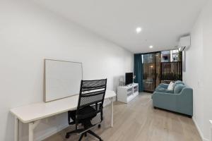 an office with a desk and a chair and a couch at 2B-1BR-1Car-Courtyard-CBD-Shops in Canberra