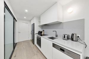 a white kitchen with a sink and a counter at 2B-1BR-1Car-Courtyard-CBD-Shops in Canberra