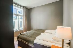 a bedroom with a bed with a lamp and a window at Moderne leilighet i Gjøvik 201 in Gjøvik