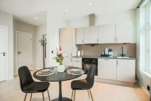 a kitchen with a table and chairs in a room at Moderne leilighet i Gjøvik 201 in Gjøvik