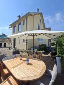 a wooden table with an umbrella in front of a house at Villa Amarinis in Saint-Amarin