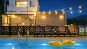 a group of chairs sitting next to a swimming pool at Gapyeong Dangdangi Pet Poolvilla Blue in Gapyeong