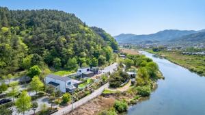 an aerial view of a river with a house at Gapyeong Dangdangi Pet Poolvilla Blue in Gapyeong