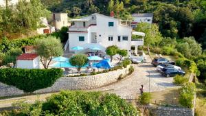 a building with cars parked in a parking lot at Villa Saranda in Supetarska Draga