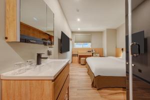 a hotel room with a bed and a sink at Whiyori Inn in Kaohsiung