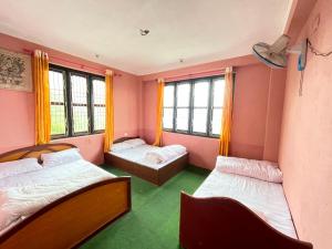 a room with two beds and two windows at Hilltop Horizon Hotel in Bandipur