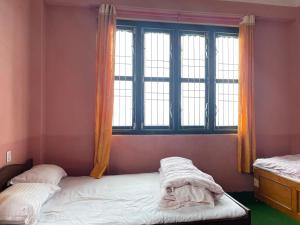 a bedroom with two beds and a window at Hilltop Horizon Hotel in Bandipur