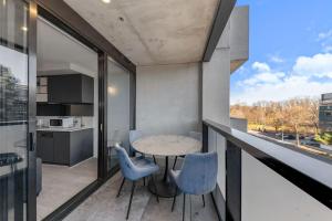 a dining room with a table and chairs on a balcony at Central CBD - parking - sleeps 4 in Canberra