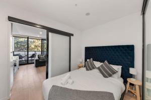 a bedroom with a large bed and a living room at Central CBD - parking - sleeps 4 in Canberra +9 photos
