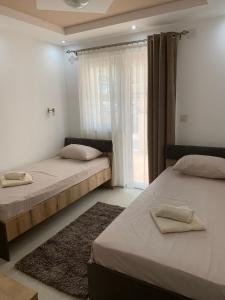 two beds in a room with a window at Eliksir in Gornja Trepča