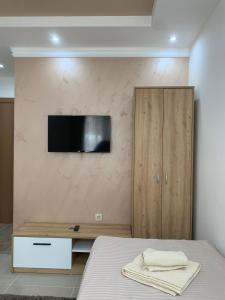 a bedroom with a bed and a tv on a wall at Eliksir in Gornja Trepča