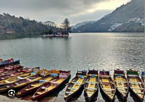 a group of boats are lined up in the water at The lake house in Bhīm Tāl