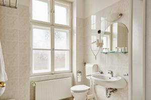 baño con aseo y lavabo y ventana en Hotel Astoria, en Balatonfüred