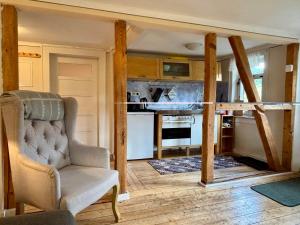 a living room with a chair and a kitchen at Weiherhof in Ehrenberg