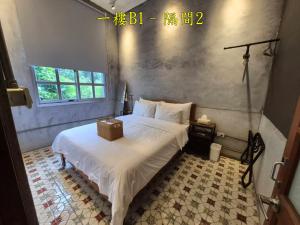 a bedroom with a white bed with a box on it at 未半文旅 in Yilan City